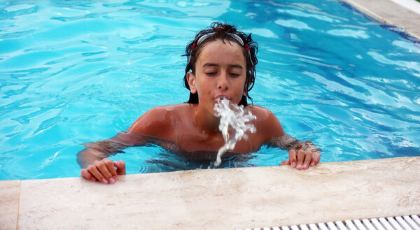 Young teenage boy spitting water out