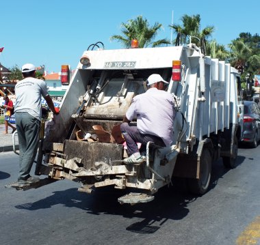 Çöp kamyonu arkasında çöp adamlar