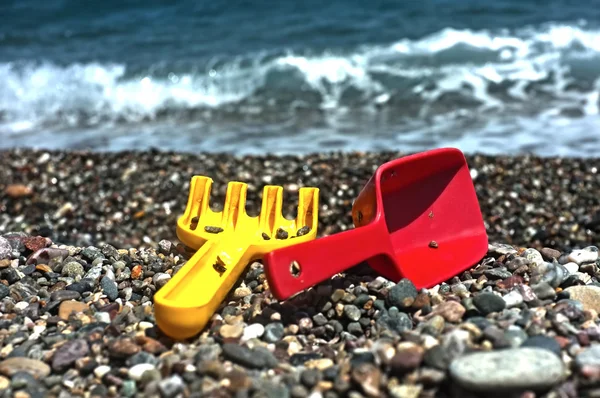 Child's rake and shovel on a beach — Stock Photo, Image