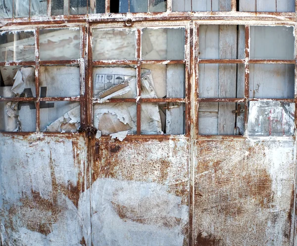 Porta metálica enferrujada abandonada de um edifício — Fotografia de Stock