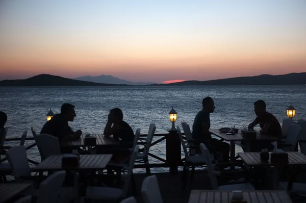 İnsanlar restoranında açık havada oturup gece karanlığında
