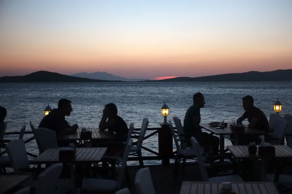 Oamenii stau în restaurant în aer liber la apus — Fotografie, imagine de stoc