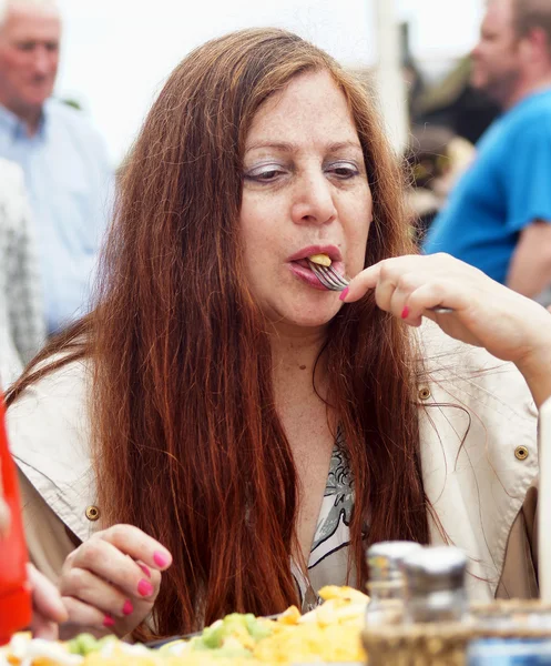 Mujer come patatas fritas al aire libre — Foto de Stock