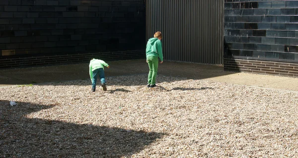 Children play with pebbles — стокове фото