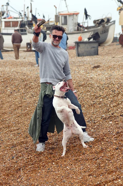 Man spelar med sin hund på stranden — Stockfoto