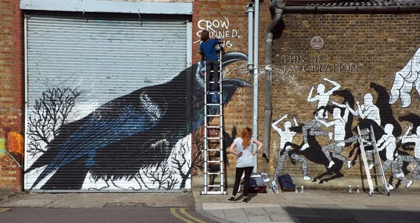 Graffiti artist paints the building wall — Zdjęcie stockowe