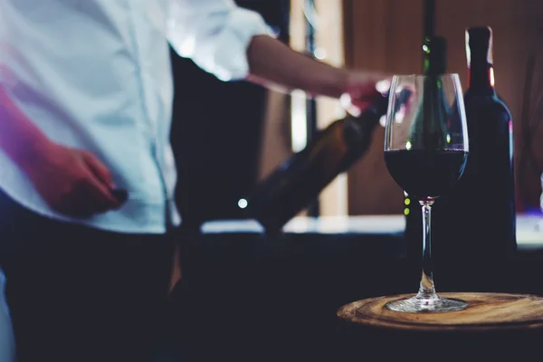 man  at  bar table having a glass of red wine