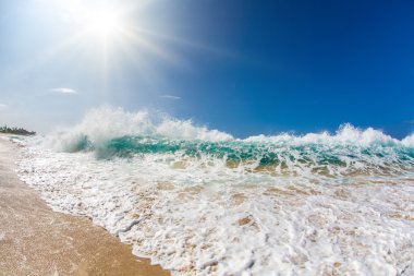 Parlak renkli okyanus dalgası ile beyaz köpük ve güneş ışığı. Sörf tropikal Shorebreak