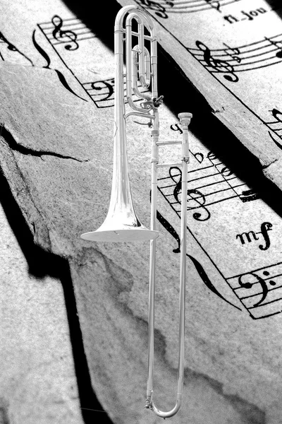 Fond texturé en papier musical avec trombone argenté — Photo