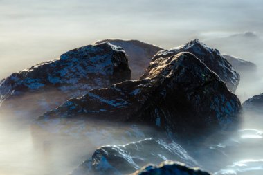 Denizin kayalık kıyısı. Yumuşak su seviyesi ve rüya etkisi için yavaş deklanşör hızı