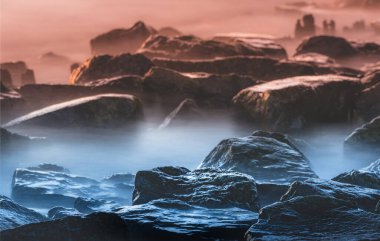 Denizin kayalık kıyısı. Yumuşak su seviyesi ve rüya etkisi için yavaş deklanşör hızı