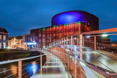 Günbatımında renkli ışıklarla aydınlatılan tiyatro, modern bir köprü ile girişe açılıyor..