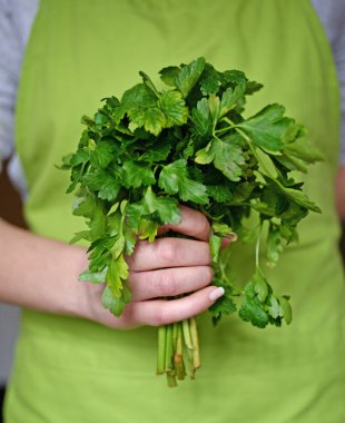 Woman holding parsley in kichen clipart