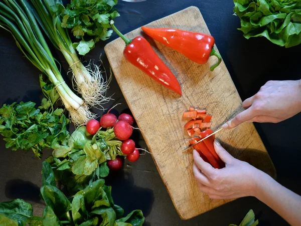 Самка режет перец для салата. Закройте повара, режьте овощи. — стоковое фото