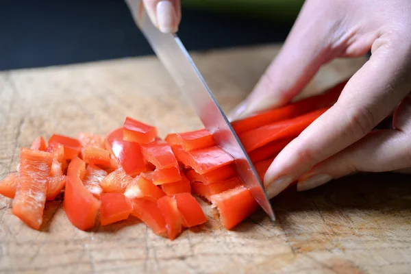Самка режет перец для салата. Закройте повара, режьте овощи. — стоковое фото