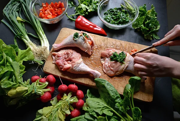 Mujer joven preparando pollo con verduras — Foto de Stock