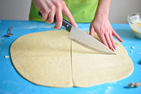 Cutting raw dough in flour with a knife — Stock Photo, Image