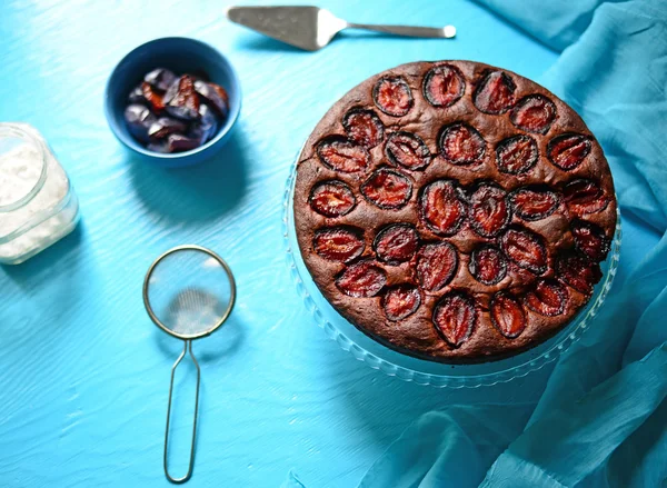 Plum cake on blue background — Stock Photo, Image