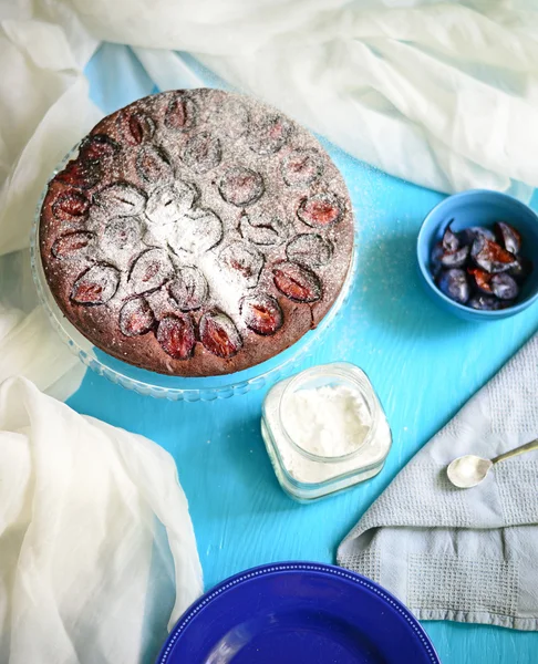 Plum cake on blue background — Stock Photo, Image