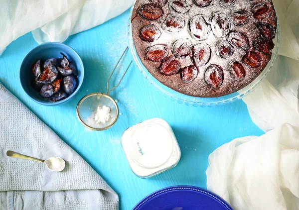 Plum cake on blue background — Stock Photo, Image