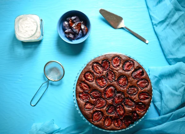 Plum cake on blue background — Stock Photo, Image