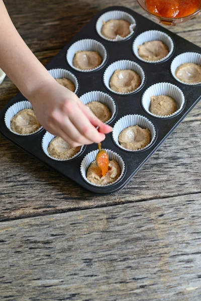 Frau bereitet gesunde Muffins mit Marmelade zu — Stockfoto