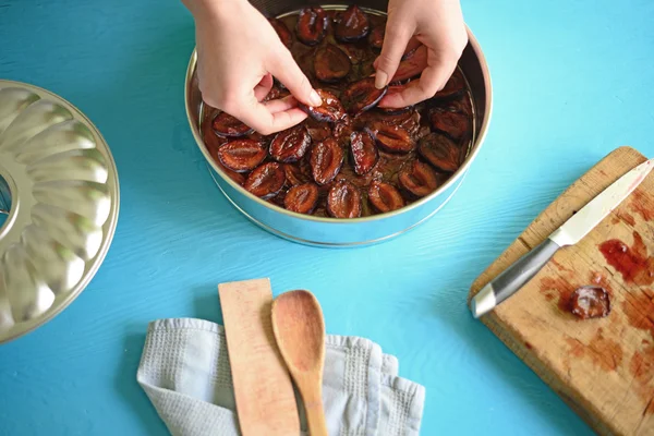 Wanita menyiapkan kue coklat dengan plum — Stok Foto