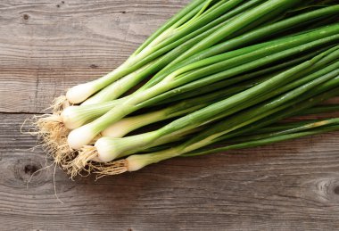 Ahşap masa üzerinde taze genç soğan