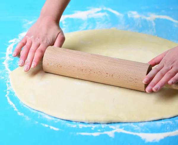 Hands baking dough with rolling pin on table — Stock Photo, Image