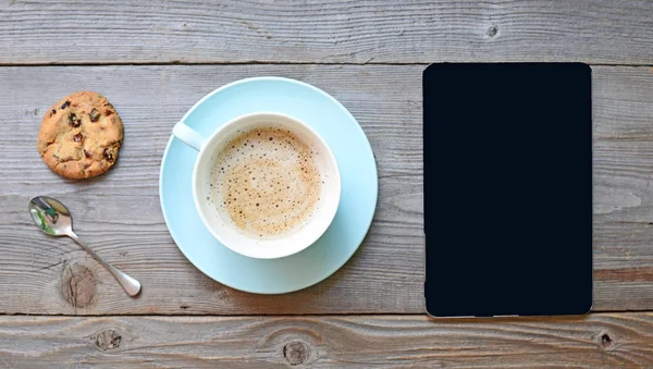 Tablet pc kijkt op ipad mini op tafel met een koffiekopje — Stockfoto