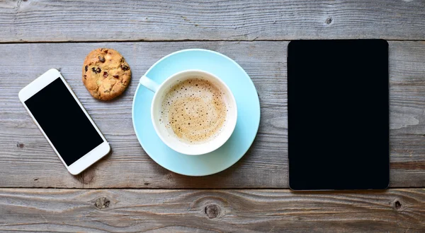 Tablet pc kijkt op ipad mini op tafel met een koffiekopje Stockfoto