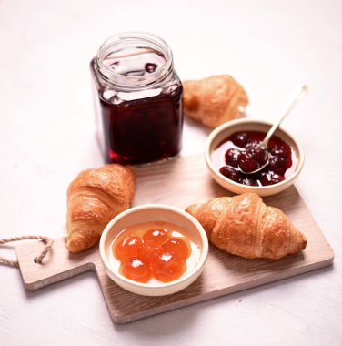 Kahvaltı ile taze kruvasanlar ve beyaz arka plan üzerinde jam