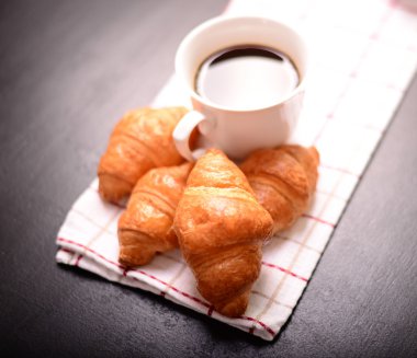 Kruvasan ve kahve siyah arka plan üzerine