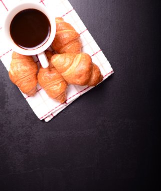 Kruvasan ve kahve siyah arka plan üzerine