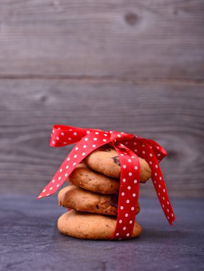 Kırmızı yay ile siyah masada çikolata kurabiye