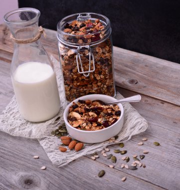 Ahşap masa üzerinde süt şişesi ile Granola Tahıl