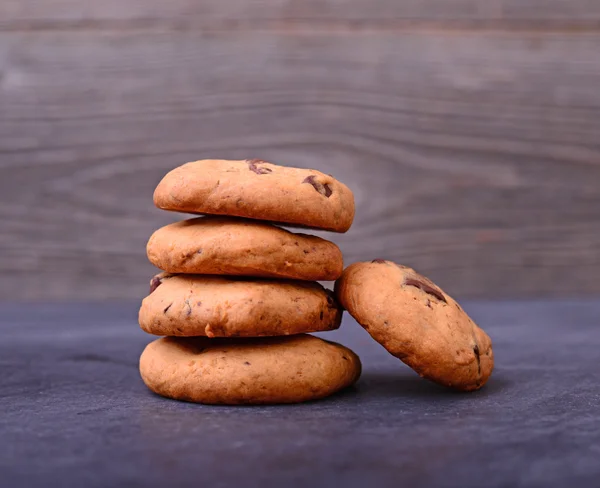 Galletas de chocolate sobre mesa negra. Galletas de chocolate apiladas — Foto de Stock