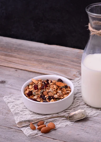 Granola zbóż z butelki mleka na drewnianym stole — Zdjęcie stockowe