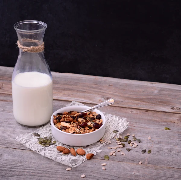 Granola Cereal con botella de leche sobre mesa de madera —  Fotos de Stock