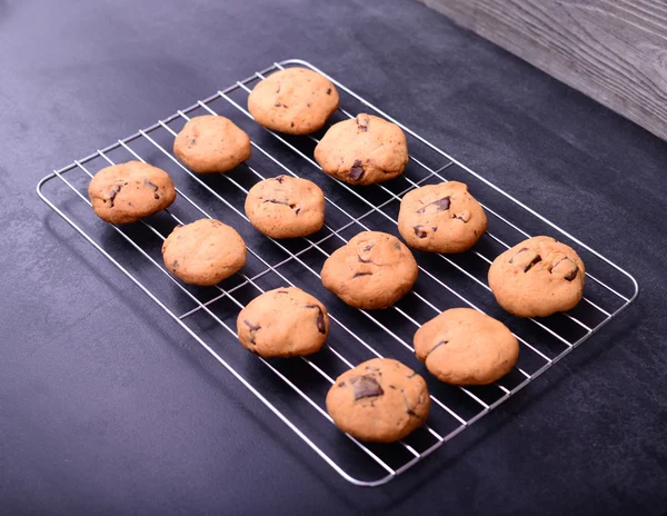 Huis gebakken chocolade koekjes op koeling rack op zwarte achtergrond — Stockfoto