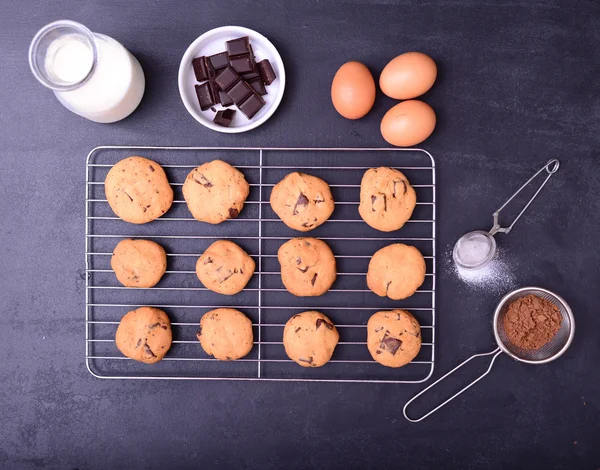 Casa biscoitos de chocolate cozidos no rack de refrigeração com ingredientes em — Fotografia de Stock
