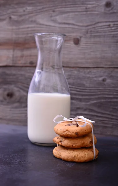 Stack of Chocolate chip cookie and bottle of milk on black backg — Stock Photo, Image