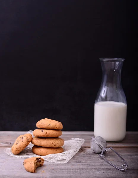 Pila de galletas fritas de chocolate y botella de leche con servilleta de encaje —  Fotos de Stock