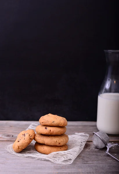 Pila de chocolate chip cookieon servilleta de encaje y botella de leche —  Fotos de Stock