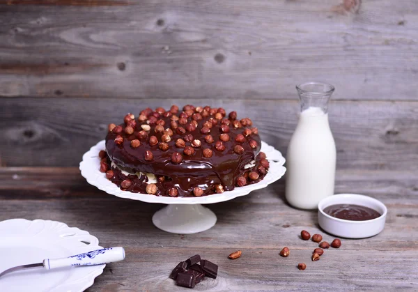 Leckere Schokoladenkuchen mit Haselnüssen auf dem Tisch und dunkler Schokolade — Stockfoto