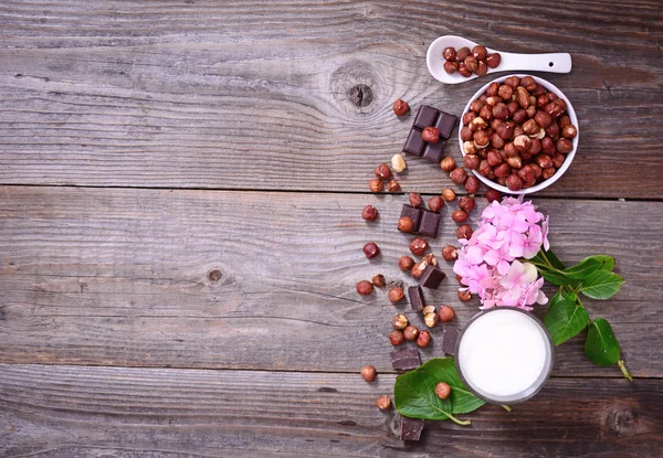 Avellana fresca, leche y chocolate negro sobre fondo de madera — Foto de Stock