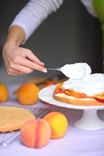 Mujer mano poner crema batida en la corteza de la torta — Foto de Stock