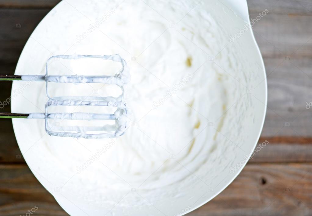 Whipped egg whites for cream on wooden table