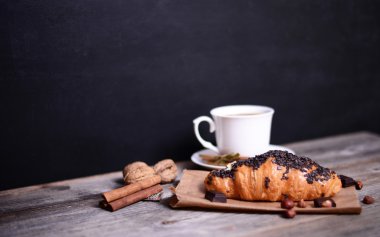 Ahşap arka plan üzerinde kahve ile Çikolatalı kruvasan