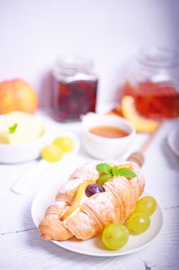 Beyaz ahşap zemin üzerine taze meyve kruvasan